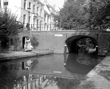 880863 Afbeelding van een beeldhouwer aan het werk op de werf langs de Nieuwegracht bij de Quintijnsbrug te Utrecht, ...
